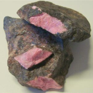 Rhodonitt. Farge rosa til rød med mørke striper/felter. Størrelse på bitene, 150 - 3100 gram. Pris er oppgitt pr. 100 gram.