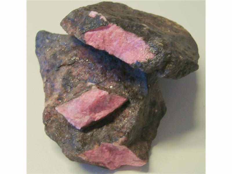 Rhodonitt. Farge rosa til rød med mørke striper/felter. Størrelse på bitene, 150 - 3100 gram. Pris er oppgitt pr. 100 gram.