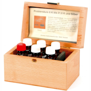 Art. 230050 Prøvesyresett. Leveres i treeske. Til sølv, samt 8, 14, 18 og 21,6 karat gull. Med prøvestein og én flaske kontrasol .